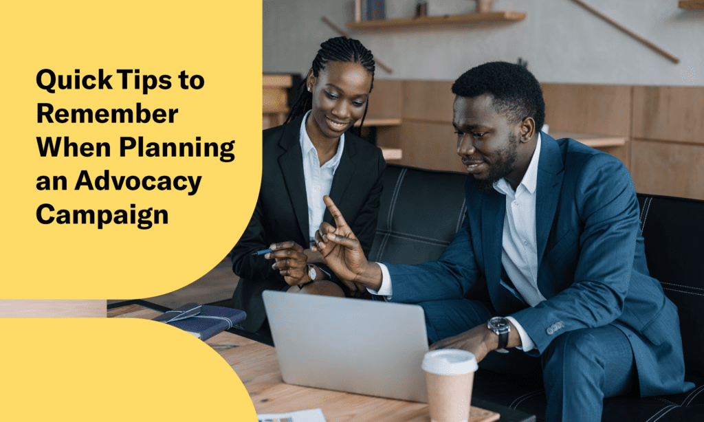 Text: "4 Quick Tips to Remember When Planning an Advocacy Campaign" Two professionals look at a computer screen and discuss.