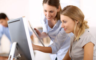 This is a picture of two women looking at a computer to choose a crowdfunding site for their next fundraising project.