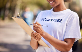 A volunteer checks off items on a clipboard, representing the post’s main topic of engaging volunteers in major campaign fundraising