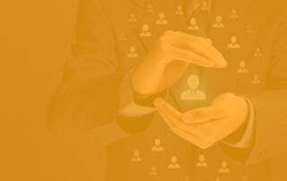 An image showing hands holding an icon representing a volunteer profile with an orange overlay.